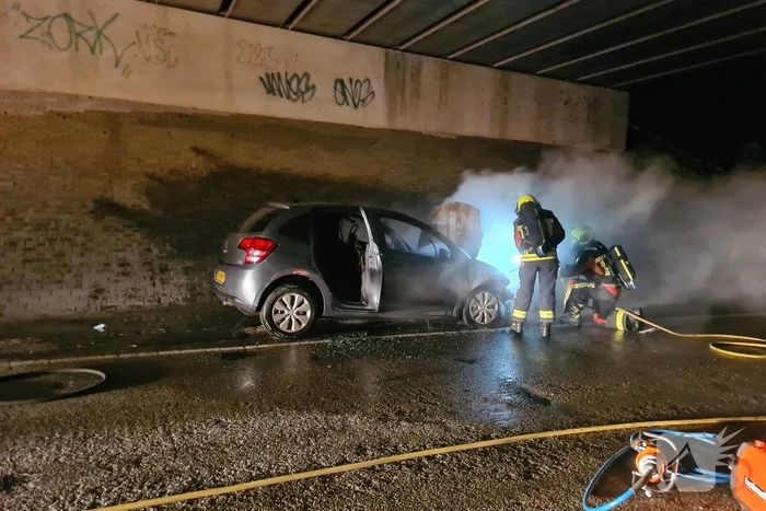 Auto vat vlam onder viaduct snelweg