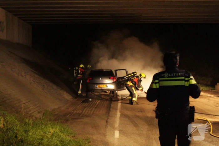 Auto vat vlam onder viaduct snelweg