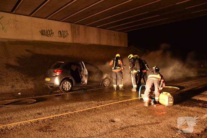 Auto vat vlam onder viaduct snelweg