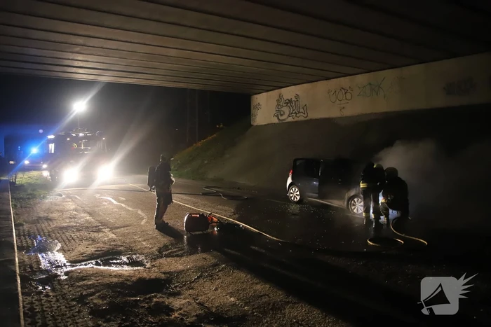 Auto vat vlam onder viaduct snelweg