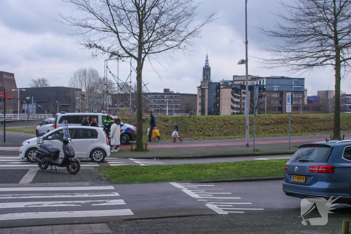 Personenauto en scooter schade na botsing