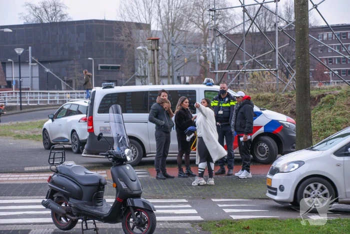 Personenauto en scooter schade na botsing