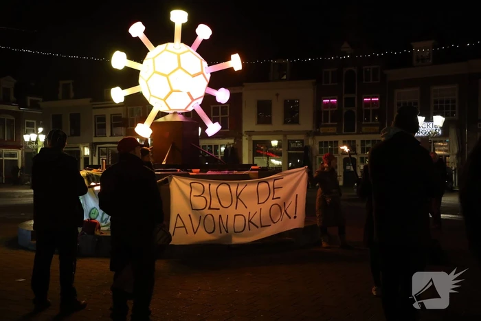 Actiegroep Viruswaarheid demonstreren tegen avondklok bij coronavirus-kunstwerk
