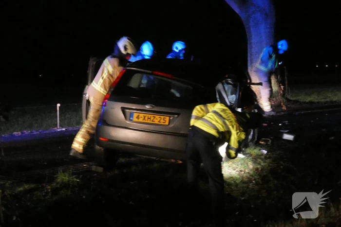Auto klapt hard tegen boom