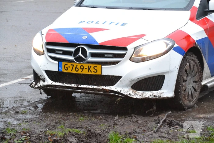Politieauto rijdt zich vast in modder