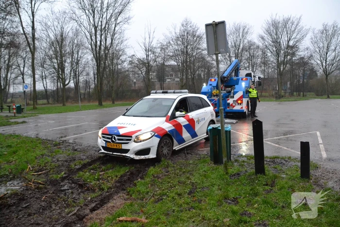 Politieauto rijdt zich vast in modder