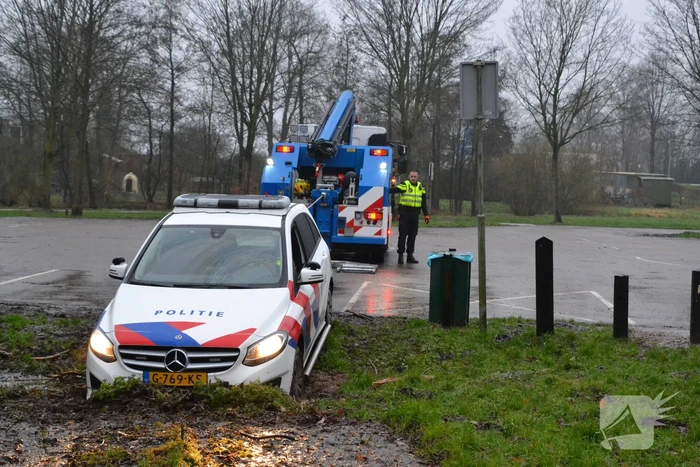 Politieauto rijdt zich vast in modder