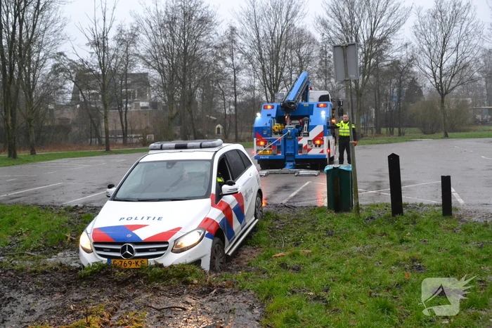 Politieauto rijdt zich vast in modder