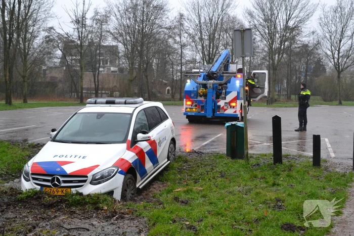 Politieauto rijdt zich vast in modder