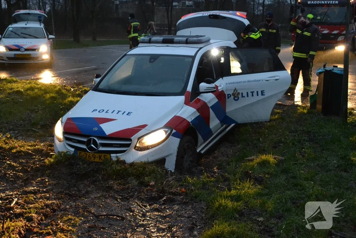 Politieauto rijdt zich vast in modder