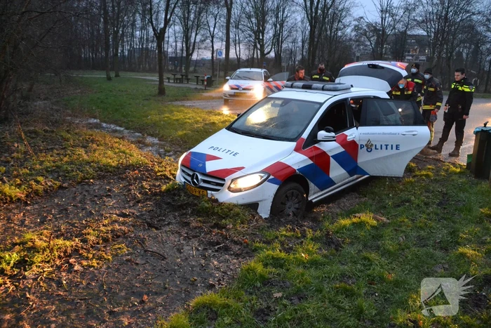 Politieauto rijdt zich vast in modder