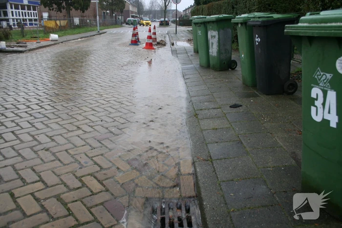 Gat in trottoir door gesprongen waterleiding