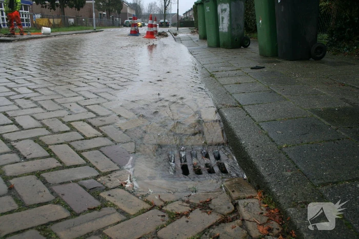 Gat in trottoir door gesprongen waterleiding