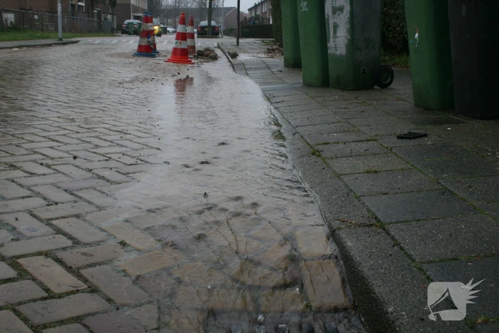 Gat in trottoir door gesprongen waterleiding
