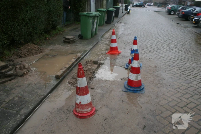 Gat in trottoir door gesprongen waterleiding