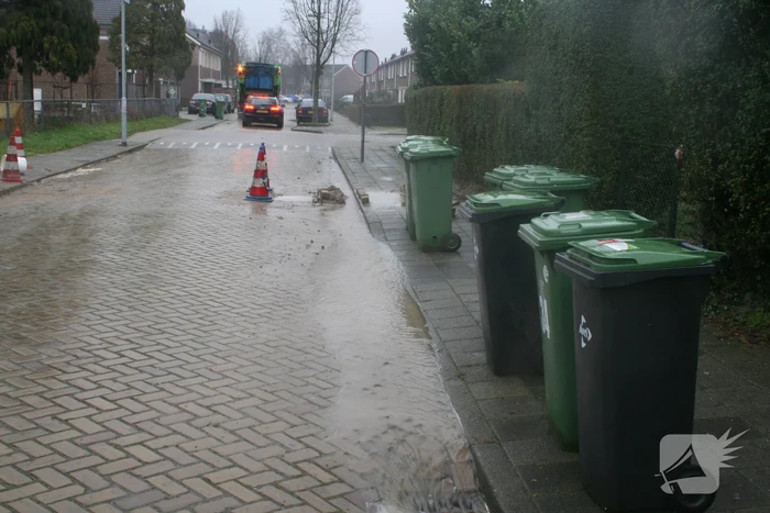 Gat in trottoir door gesprongen waterleiding