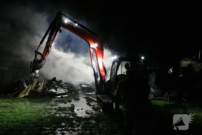 Grote uitslaande brand in loods achter woning