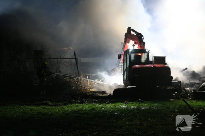 Grote uitslaande brand in loods achter woning
