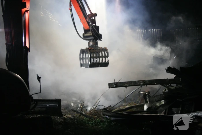 Grote uitslaande brand in loods achter woning