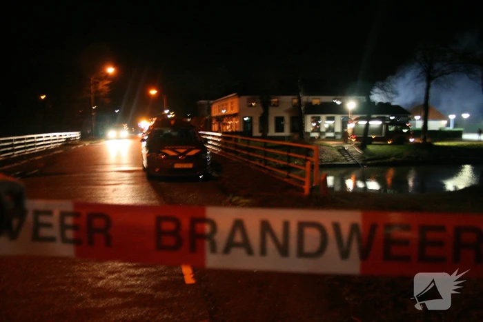 Grote uitslaande brand in loods achter woning