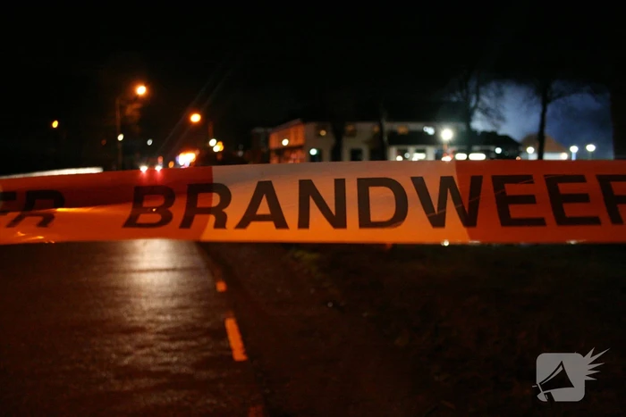 Grote uitslaande brand in loods achter woning