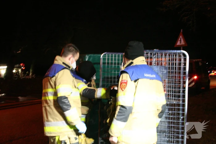 Grote uitslaande brand in loods achter woning