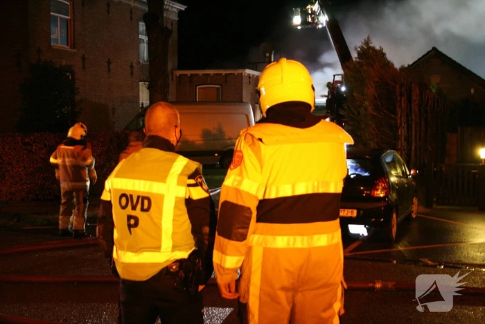 Grote uitslaande brand in loods achter woning