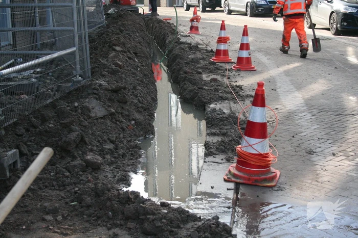Sleuf vol water na waterleidingbreuk
