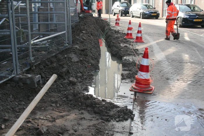 Sleuf vol water na waterleidingbreuk