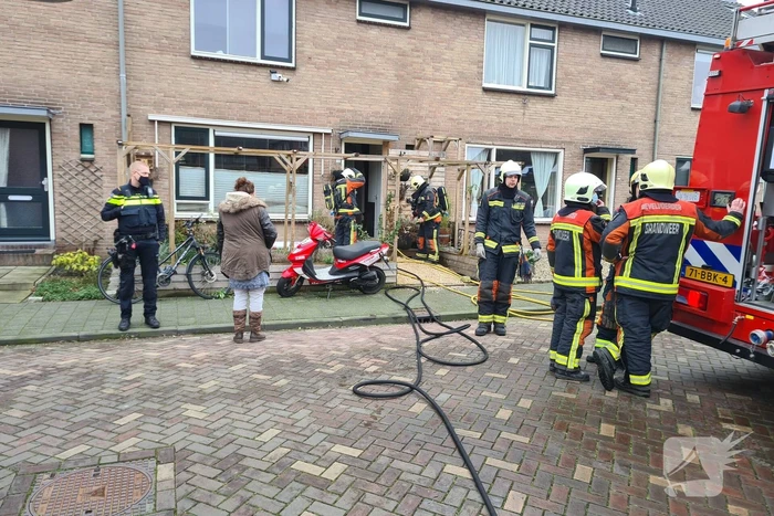 Kleding in woning vliegt in brand