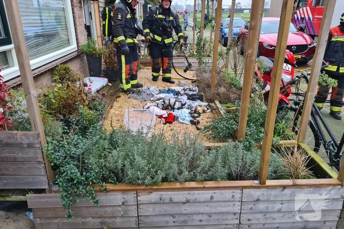 Kleding in woning vliegt in brand