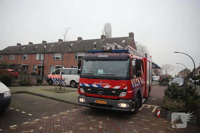 Kleding in woning vliegt in brand