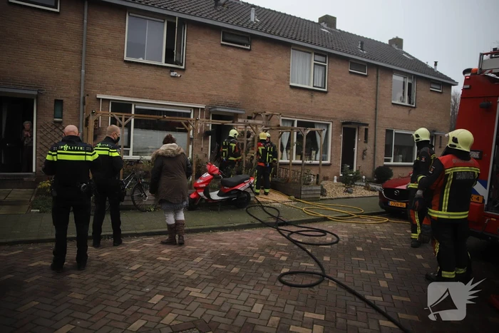 Kleding in woning vliegt in brand