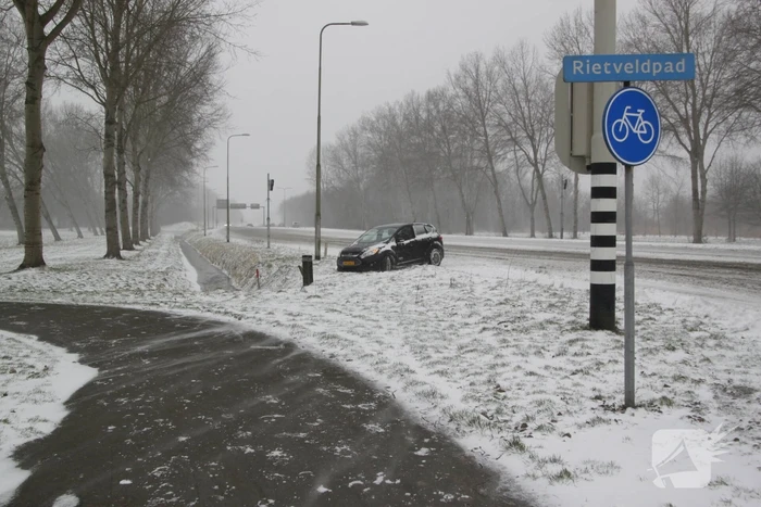 Auto naast de weg en vast in sneeuw