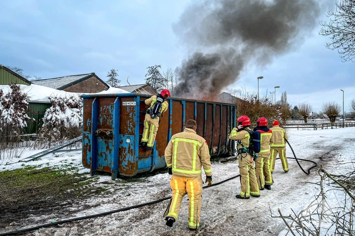 Felle brand in container met bouwafval