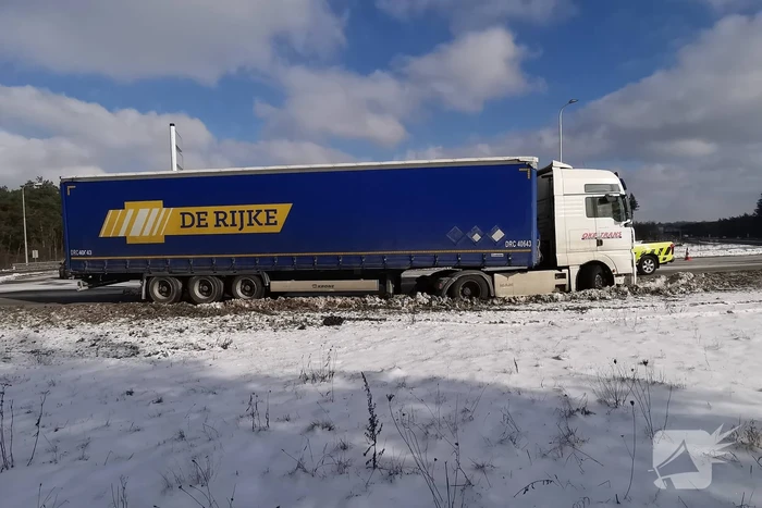 Vrachtwagen met oplegger vast in berm