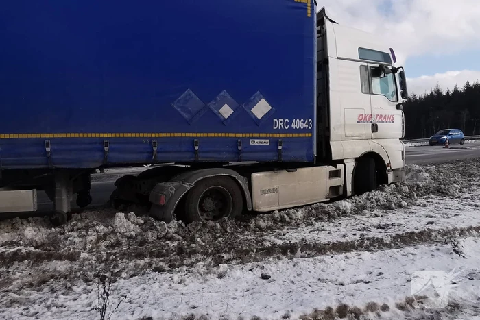 Vrachtwagen met oplegger vast in berm