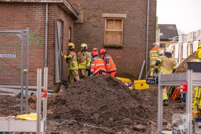 Persoon bekneld onder betonnen plaat