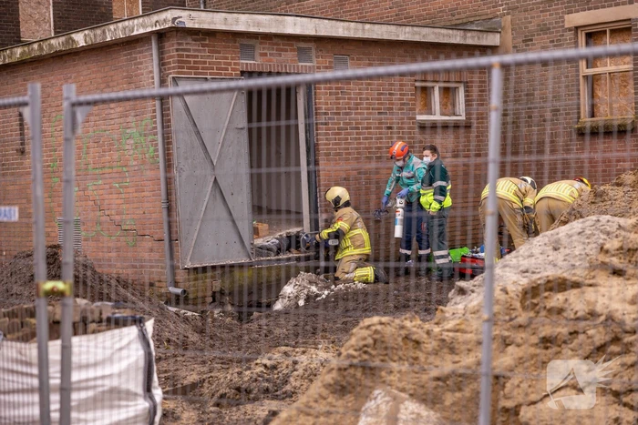 Persoon bekneld onder betonnen plaat