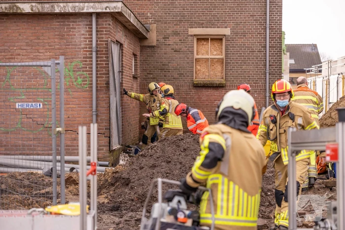 Persoon bekneld onder betonnen plaat
