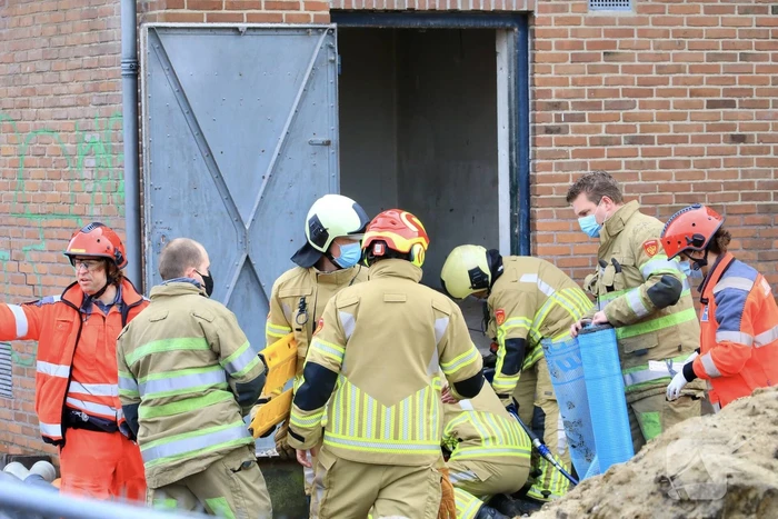 Persoon bekneld onder betonnen plaat