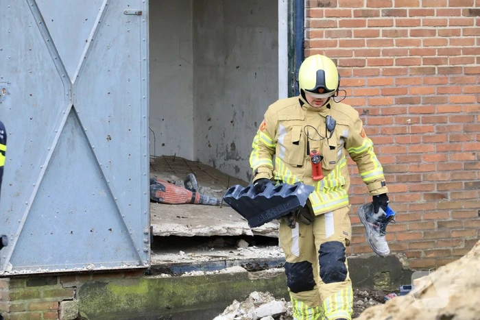 Persoon bekneld onder betonnen plaat