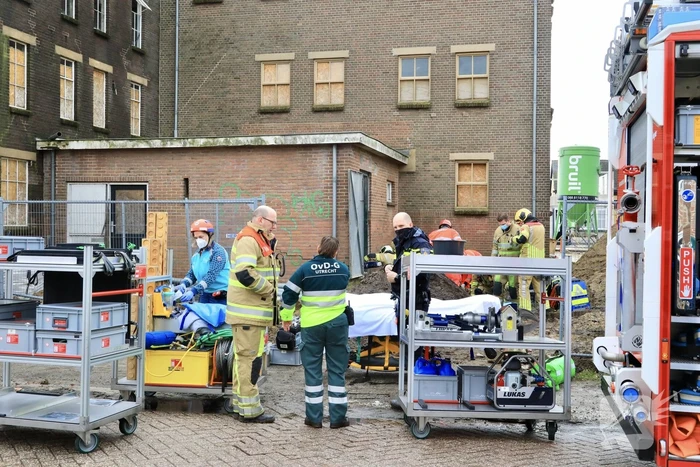 Persoon bekneld onder betonnen plaat