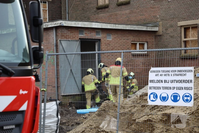 Persoon bekneld onder betonnen plaat
