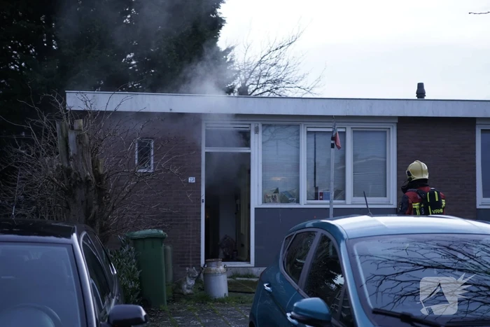 Brandweer blust brandende pan in woning