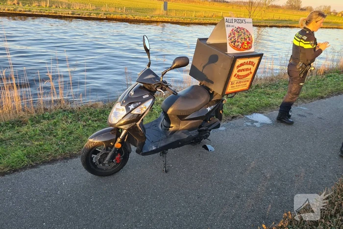 Bezorger met scooter onderuit