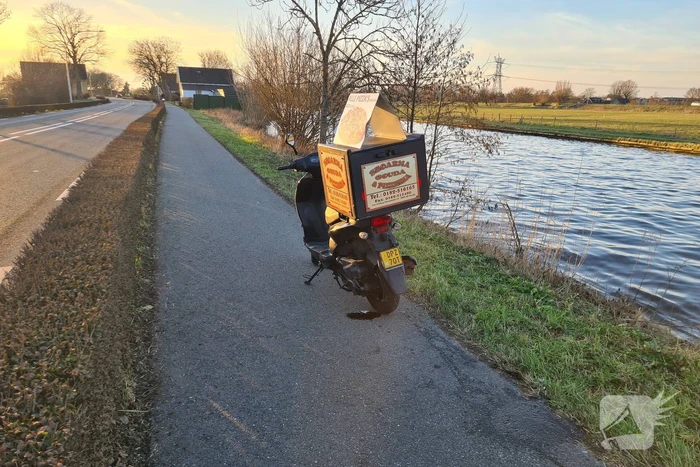 Bezorger met scooter onderuit
