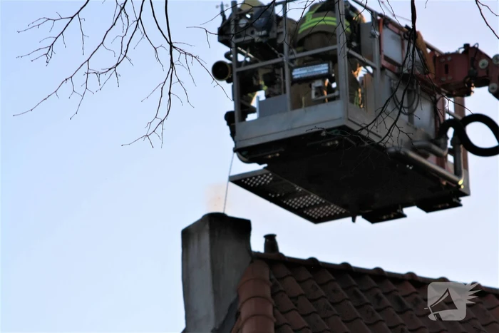 Brandweer veegt schoorsteen na brand