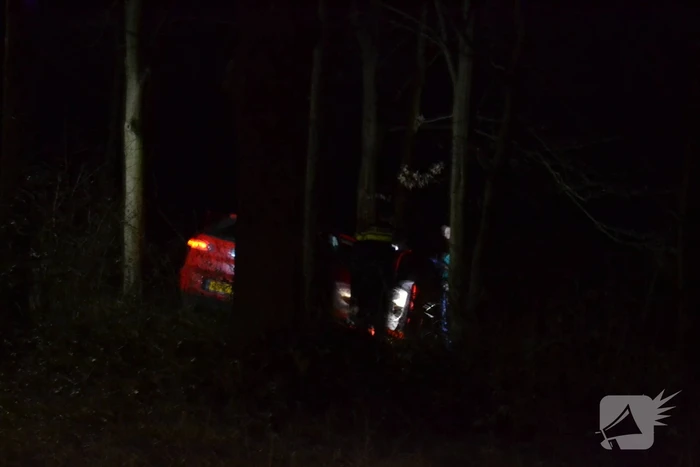 Auto vliegt uit de bocht en belandt tussen de bomen