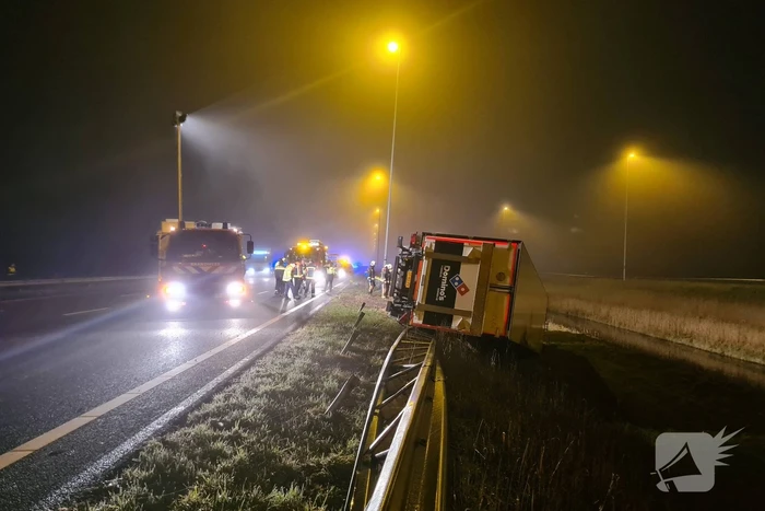 Vrachtwagen belandt op zijn kant in middenberm